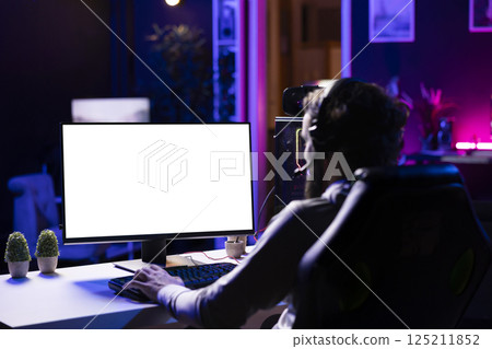 Player having fun by using isolated screen computer display to play singleplayer videogame. Professional gamer using mockup PC desktop to complete levels in game, talking with friends 125211852