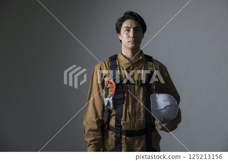 Male worker wearing a full harness 125213156