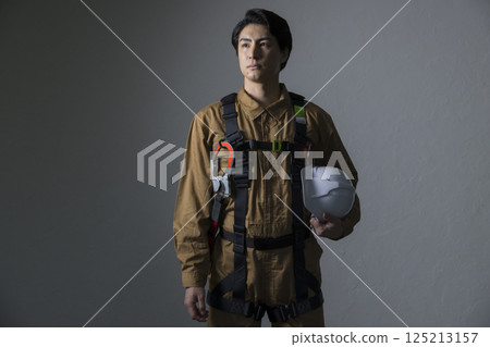 Male worker wearing a full harness 125213157