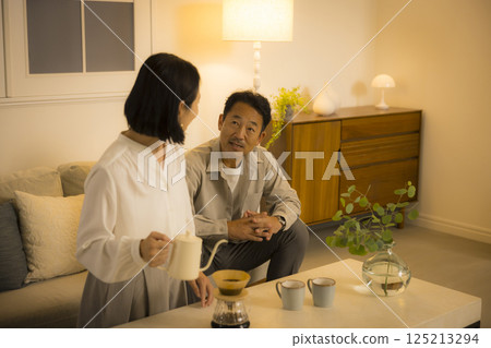 Middle-aged couple in the living room at night Middle-aged couple in the living room at night 125213294