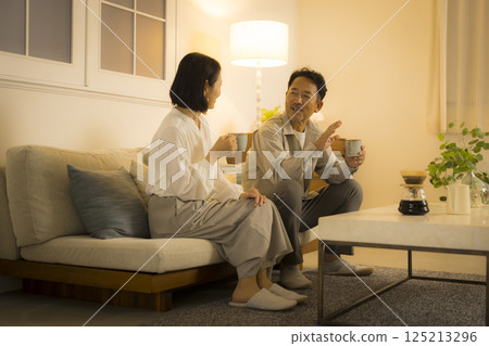 Middle-aged couple in the living room at night Middle-aged couple in the living room at night 125213296