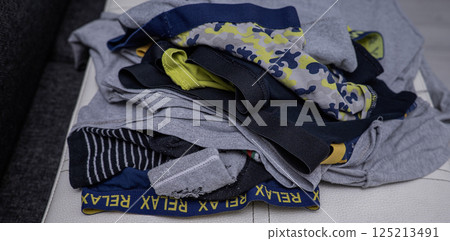 While waiting to fold dry children's clothes after washing 125213491