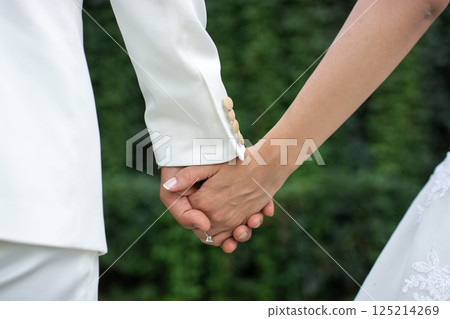 Wedding couples holding hands on green background. 125214269