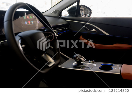 Modern car interior with black steering wheel, digital instrument panel 125214860