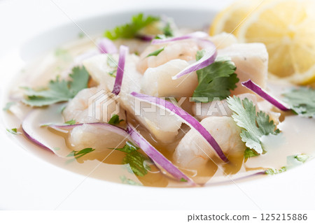 Traditional Peruvian ceviche sea bass fillet isolated on white background. Traditional Peruvian ceviche sea bass fillet isolated on white background. 125215886