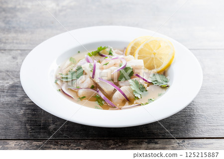 Traditional Peruvian ceviche sea bass fillet on wooden table Traditional Peruvian ceviche sea bass fillet on wooden table 125215887