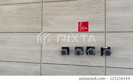 Fire extinguishing pipe connection system. Wall sign indicating location of fire engine connection to dry water supply in an emergency. Dry water system for building safety in fire Fire extinguishing pipe connection system. Wall sign indicating location of fire engine connection to dry water supply in an emergency. Dry water system for building safety in fire 125216144