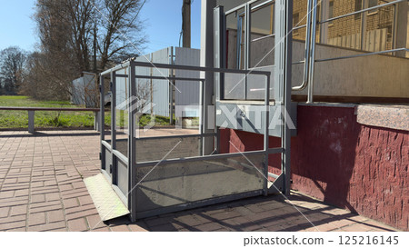 Safe elevator for wheelchair users. Outdoor elevator for access to building for people with disabilities. Accessible environment device for people with disabilities. Caring for people in modern city Safe elevator for wheelchair users. Outdoor elevator for access to building for people with disabilities. Accessible environment device for people with disabilities. Caring for people in modern city 125216145