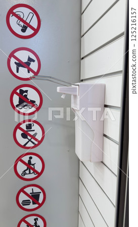 Signs with rules at entrance to store prohibiting smoking, food and drinks, use of roller skates and scooters next to antiseptic dispenser. Strict restrictions in store to ensure safety of goods Signs with rules at entrance to store prohibiting smoking, food and drinks, use of roller skates and scooters next to antiseptic dispenser. Strict restrictions in store to ensure safety of goods 125216157