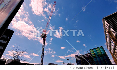 Looking up at the sky from the valley of the building 125216451