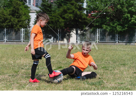 Boy making a slide tackle during soccer match outdoors. Boy making a slide tackle during soccer match outdoors. 125216543