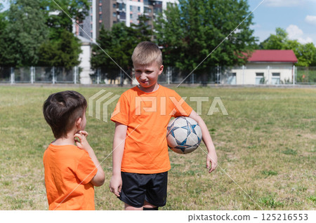 Two boys talking during soccer break on sunny field. Two boys talking during soccer break on sunny field. 125216553
