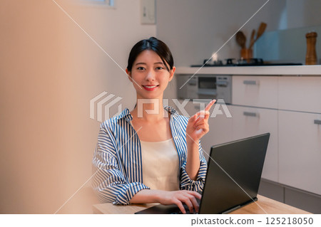 Young woman working from home late into the night 125218050