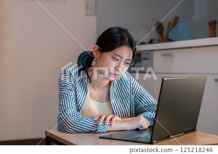 Young woman tired from working from home for long hours Young woman tired from working from home for long hours 125218246