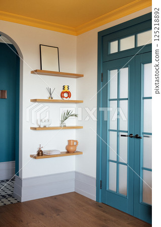 Close-up details of a stylish home interior. Wooden shelves with handmade vases and jugs, books and incense sticks. 125218892