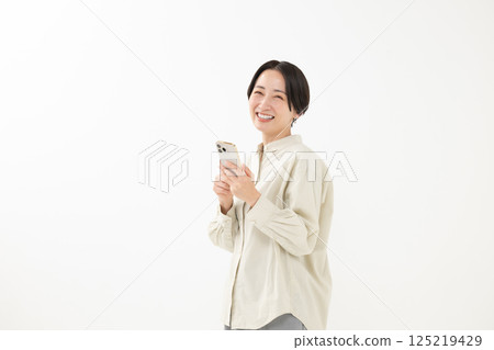 Woman holding a smartphone with a smile Woman holding a smartphone with a smile 125219429