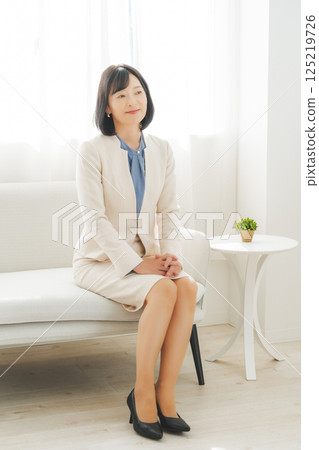 Image of a middle-aged career woman in a white suit Image of a middle-aged career woman in a white suit 125219726