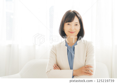 Image of a middle-aged career woman in a white suit 125219739
