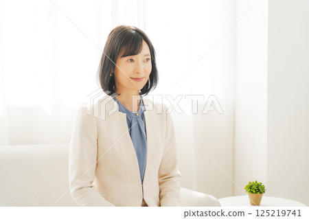 Image of a middle-aged career woman in a white suit 125219741