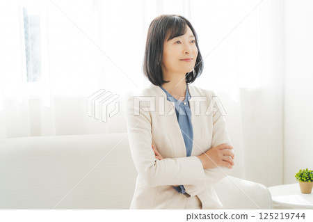 Image of a middle-aged career woman in a white suit 125219744