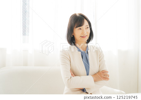 Image of a middle-aged career woman in a white suit 125219745