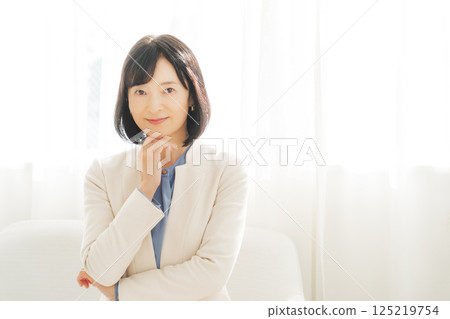 Image of a middle-aged career woman in a white suit 125219754