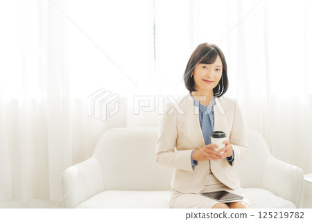 A middle-career woman taking a break with a drink 125219782