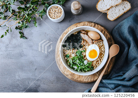 Cozy comfort food concept: steaming hot ramen with pork, egg, seaweed and colorful toppings 125220456