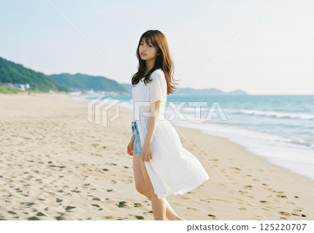 Woman walking on a calm summer sandy beach 125220707