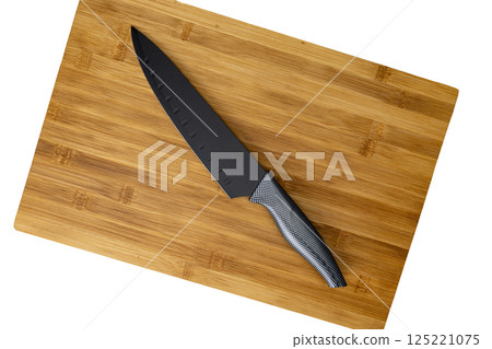 Black Knife on Bamboo Cutting Board on white background Black Knife on Bamboo Cutting Board on white background 125221075