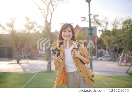 traveler young Asian woman in her 30s navigates the vibrant streets of Bangkok. Let this photo inspire your own journey. 125221633