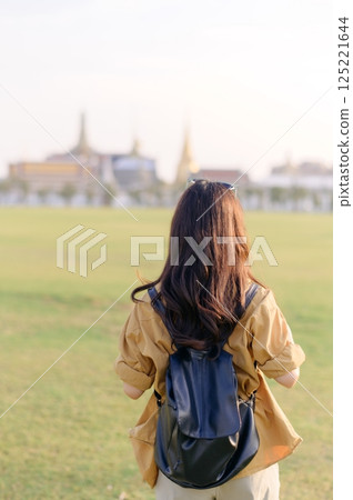 A Traveler Asian woman in her 30s exploring Wat Pra Kaew. From stunning architecture to friendly locals, she cherishes every moment, capturing it all in her heart and camera for years to come. 125221644