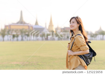 A Traveler Asian woman in her 30s exploring Wat Pra Kaew. From stunning architecture to friendly locals, she cherishes every moment, capturing it all in her heart and camera for years to come. 125221658