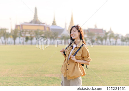 A Traveler Asian woman in her 30s exploring Wat Pra Kaew. From stunning architecture to friendly locals, she cherishes every moment, capturing it all in her heart and camera for years to come. 125221661
