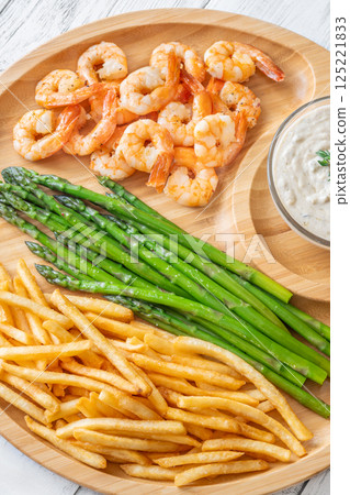 Rustic wooden tray serves full meal of shrimp, asparagus, fries, and sauce Rustic wooden tray serves full meal of shrimp, asparagus, fries, and sauce 125221833