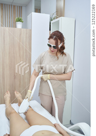 Female technician performing laser hair removal on caucasian adult woman Female technician performing laser hair removal on caucasian adult woman 125222169