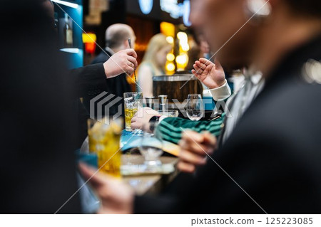 Crafting exquisite cocktails at an upscale bar during a lively evening gathering 125223085