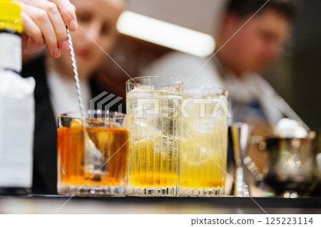 Mixing vibrant cocktails at a stylish bar during evening hours Mixing vibrant cocktails at a stylish bar during evening hours 125223114