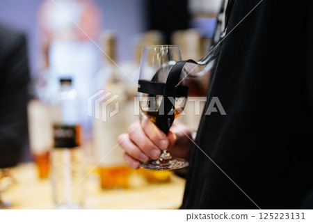 Elegant glass holding whiskey at a sophisticated tasting event Elegant glass holding whiskey at a sophisticated tasting event 125223131