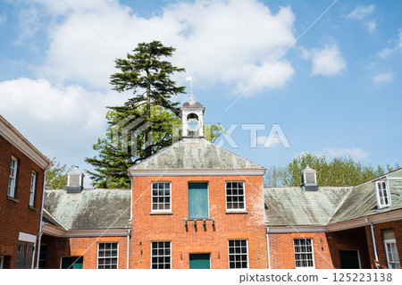 A red brick building with a historic clock tower under bright blue skies in Hatchlands, a suburb of London A red brick building with a historic clock tower under bright blue skies in Hatchlands, a suburb of London 125223138