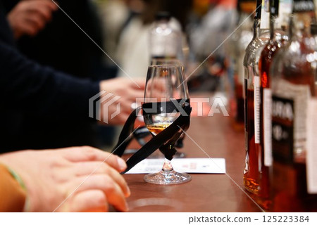 Tasting fine spirits at a local distillery event in the evening glow Tasting fine spirits at a local distillery event in the evening glow 125223384