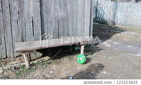 A Cozy Rustic Bench and a Bright Soccer Ball Set in a Beautiful Outdoor Environment A Cozy Rustic Bench and a Bright Soccer Ball Set in a Beautiful Outdoor Environment 125223625