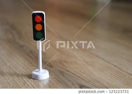 A Miniature Traffic Light Model on a Wood Floor, creating a vibrant and engaging atmosphere 125223731