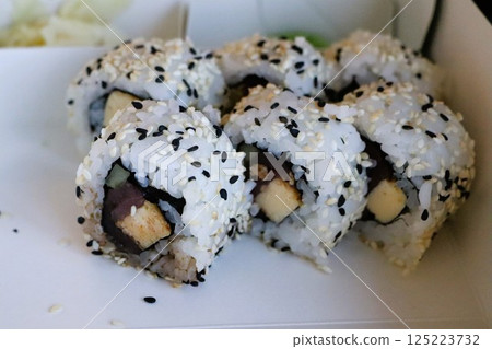 Enjoy Delicious Sushi Rolls Topped with Flavorful Sesame Seeds and Fresh Ingredients 125223732