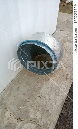 A Rustic Metal Cylinder Positioned Against a Wall in an Outdoor Environment and Setting 125223759