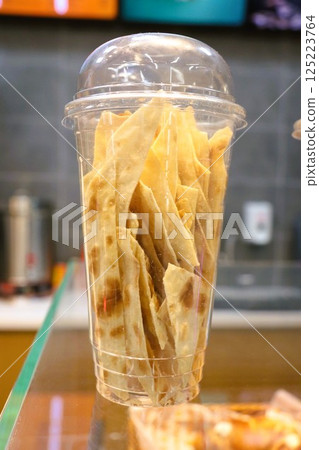 Enjoy a Delicious and Crispy Snack Presented in a Transparent Cup for All Occasions 125223764
