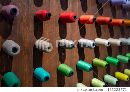 Colorful silk yarn bobbins on wooden background. Colorful silk yarn bobbins on wooden background. 125223771