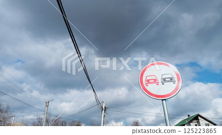 A No Parking Sign Is Prominently Displayed Beneath An Overcast Sky Filled With Clouds 125223865