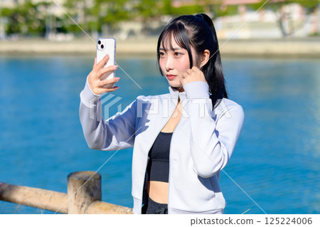 Cute woman taking a selfie with her smartphone in hand Selfie SNS Daily life Photogenic Cropped up 125224006