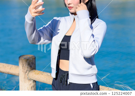 Cute woman taking a selfie with her smartphone in hand Selfie SNS Everyday Photogenic No face Cropped up 125224007